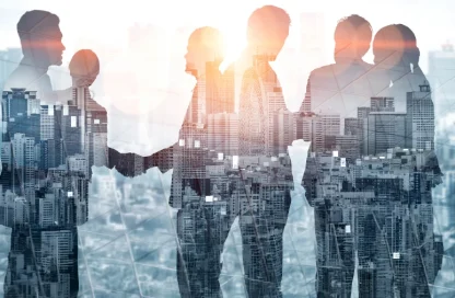 Silhouettes of business colleagues shaking hands over a cityscape, symbolizing collaboration.