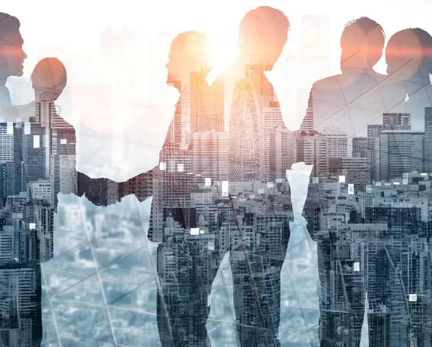 Silhouettes of business colleagues shaking hands over a cityscape, symbolizing collaboration.